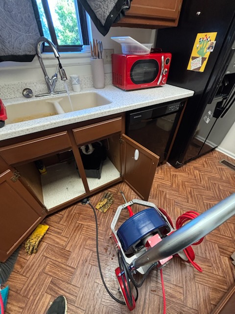 Plumber clearing a residential drain line
